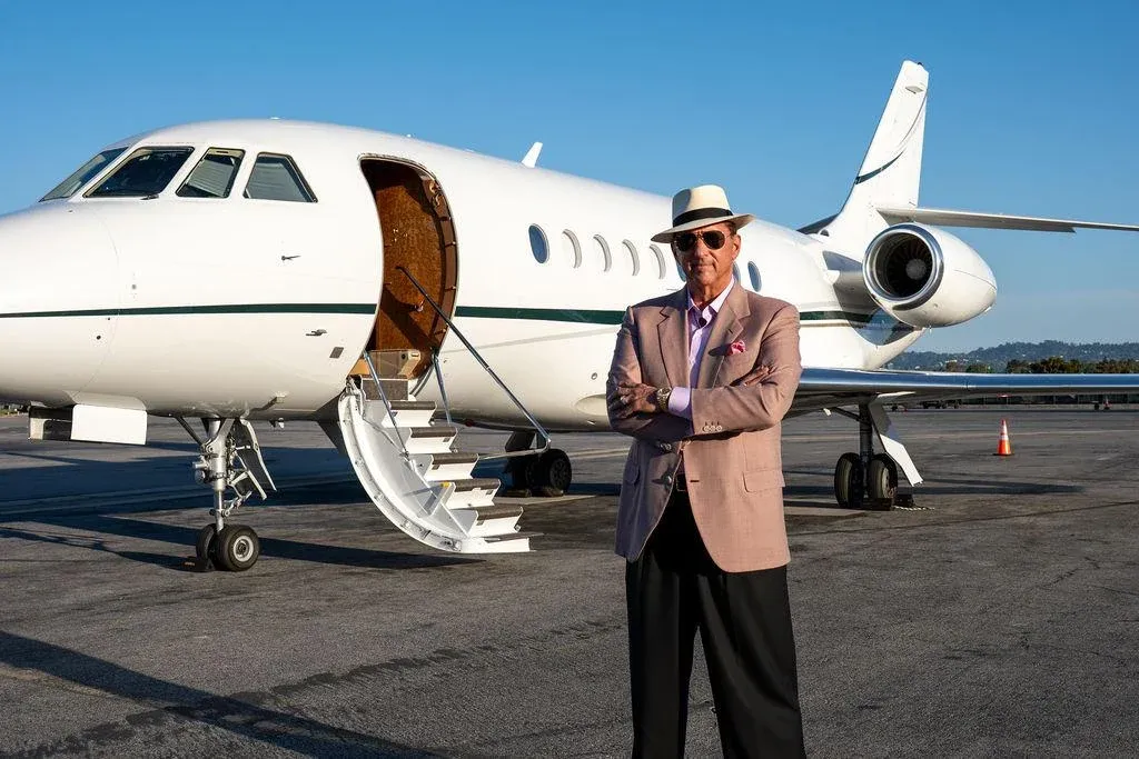 Kevin Trudeau standing in front of a private jet